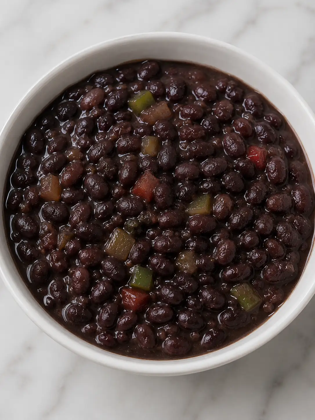 Bowl of caraotas negras, Venezuelan black beans, topped with white cheese and cilantro